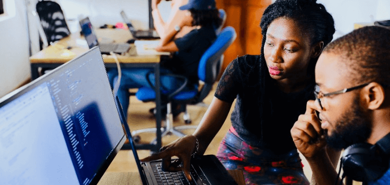 Image of two people looking at a computer screen depicting Lifebit's technology solutions for data accuracy